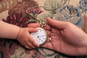 La main d'un adulte transmet une montre à la main d'un enfant